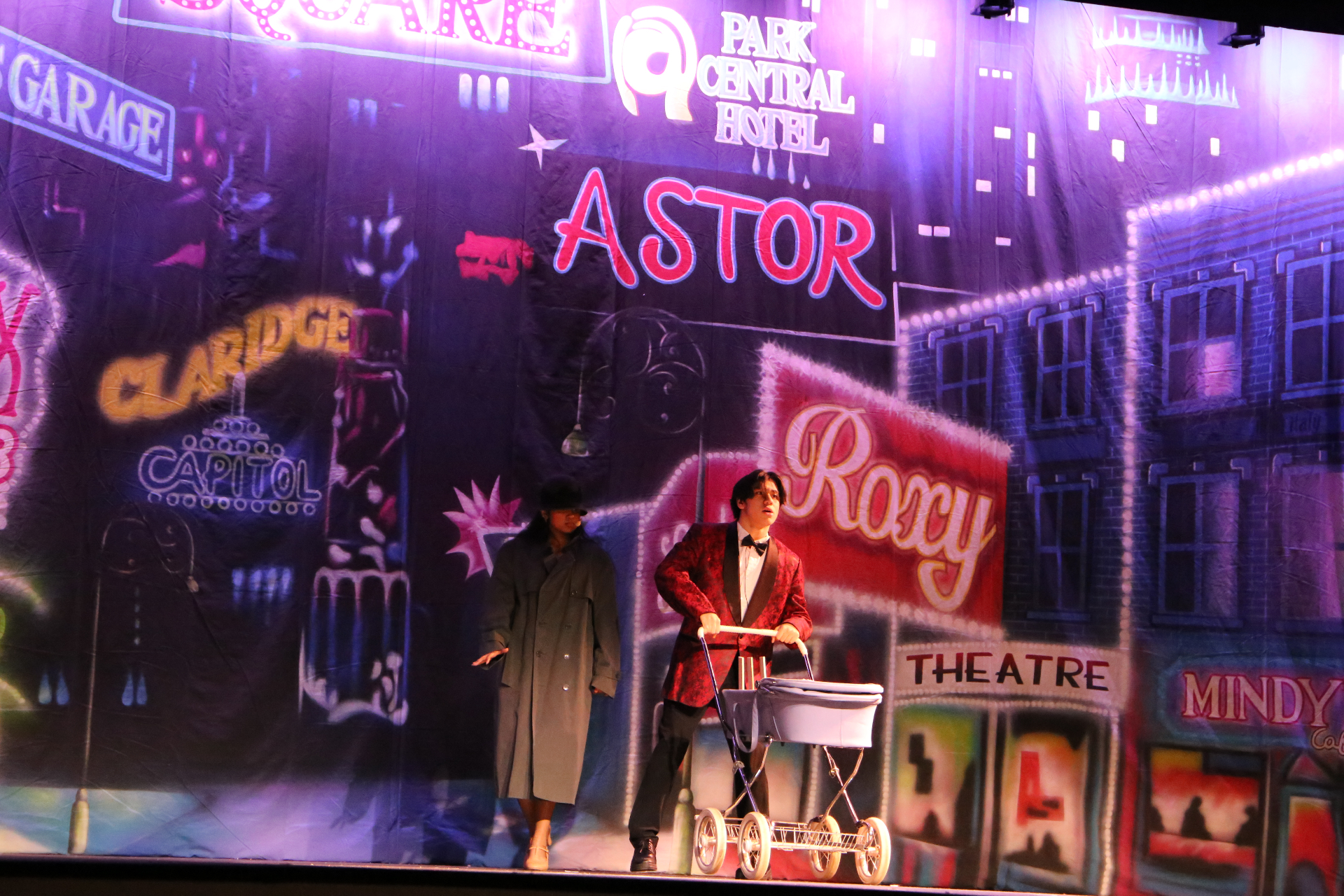 MC under the ASTOR sign with stroller