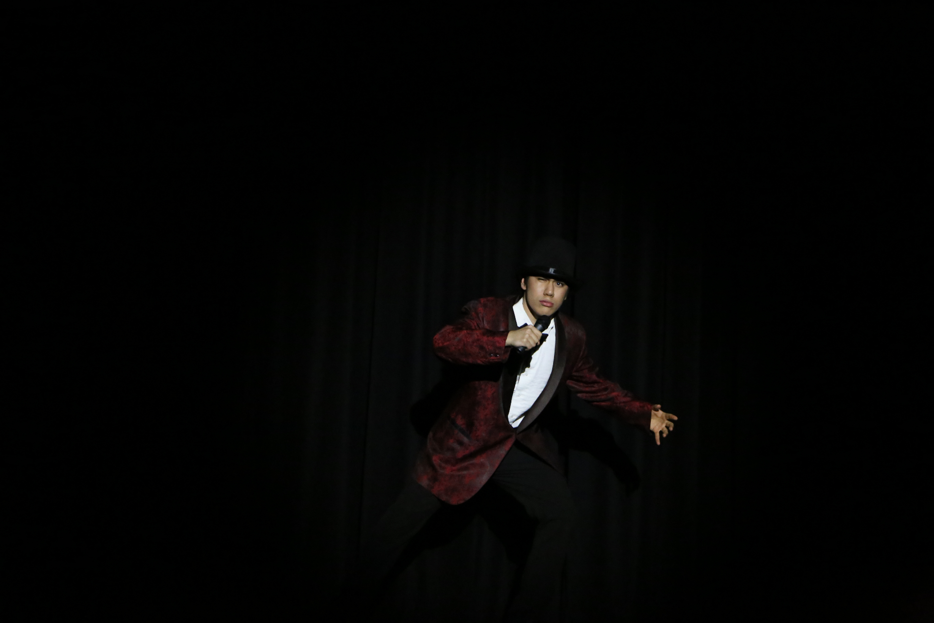 Solo black-curtain spotlight in red jacket